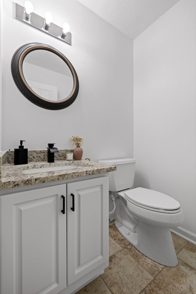 9240 Shay Cv, Ooltewah, TN 37363 - half bathroom featuring toilet, vanity, a textured ceiling, and stone finish flooring