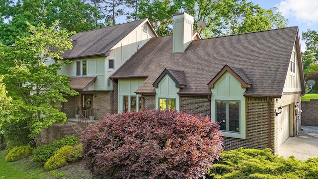 9240 Shay Cv, Ooltewah, TN 37363 - view of front of property featuring brick siding, board and batten siding, driveway, a shingled roof, and a chimney