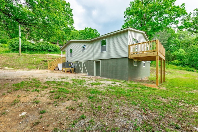 rear view of property featuring a wooden deck and stairs