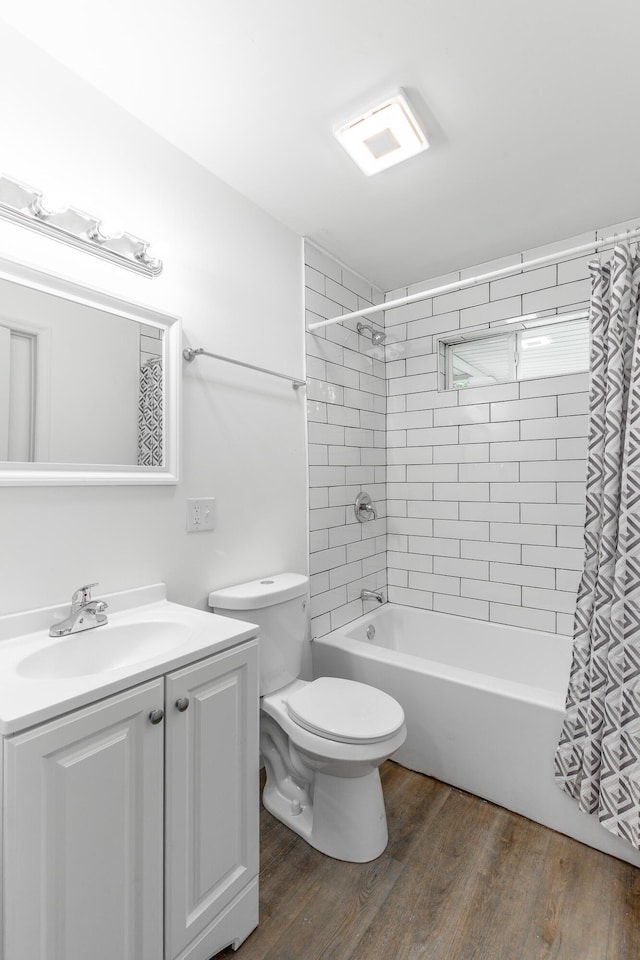 full bath featuring vanity, wood finished floors, shower / bath combo, and toilet