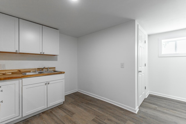 kitchen featuring baseboards, a sink, and wood finished floors