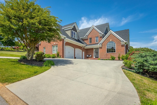 traditional home featuring brick siding, a front lawn, an attached garage, and driveway
