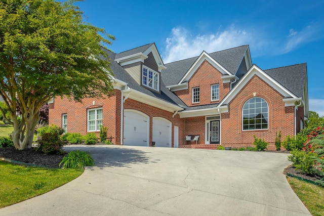 traditional-style home featuring concrete driveway, brick siding, roof with shingles, and a garage