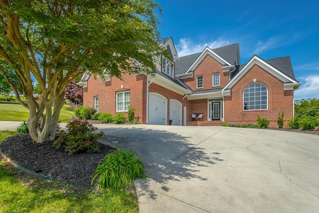 traditional-style home with brick siding, an attached garage, and driveway