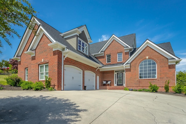 traditional-style house with concrete driveway, brick siding, roof with shingles, and a garage