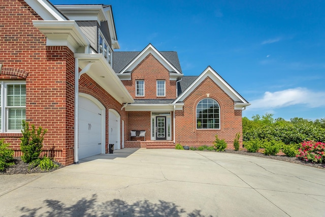 view of front of home with brick siding, driveway, a shingled roof, and a garage