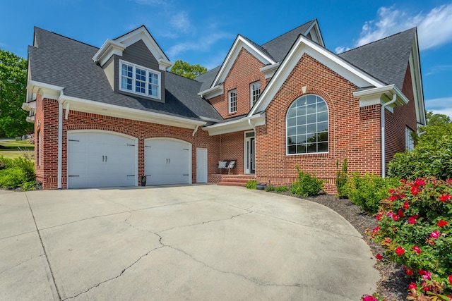 traditional-style home with concrete driveway, brick siding, roof with shingles, and a garage