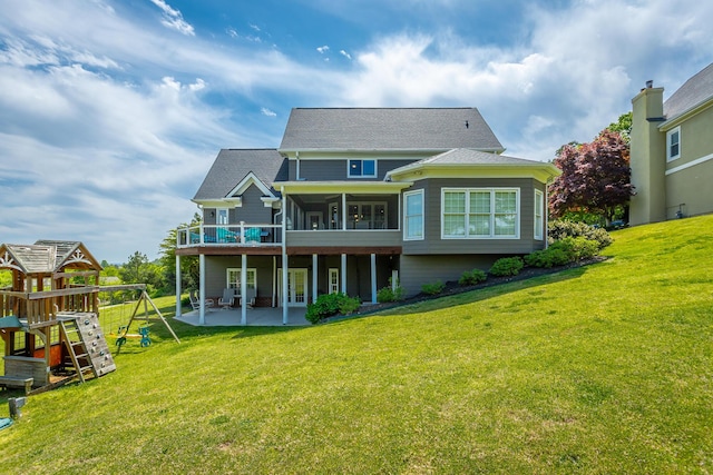 rear view of house featuring a lawn, a patio, a sunroom, and a playground