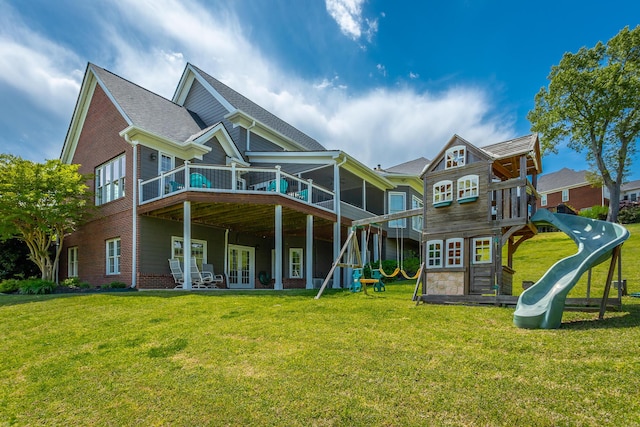 back of property featuring a yard, a deck, french doors, and a playground