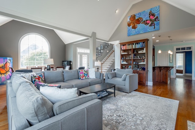 living room with baseboards, high vaulted ceiling, wood finished floors, and stairway
