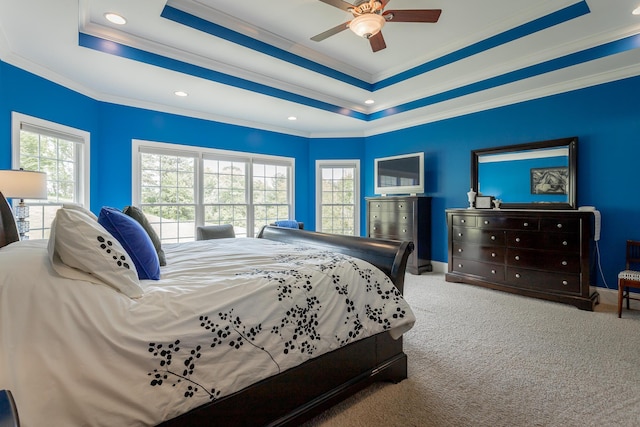 carpeted bedroom with crown molding, recessed lighting, baseboards, and a raised ceiling