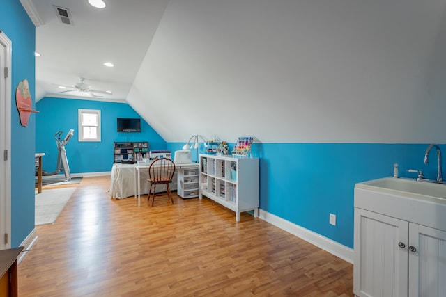 office featuring a sink, baseboards, light wood-style floors, and lofted ceiling