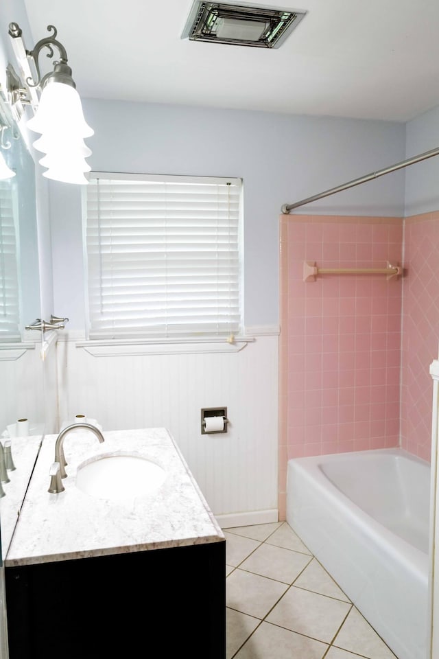 full bath featuring vanity, visible vents, tile patterned floors, a wainscoted wall, and shower / bath combination