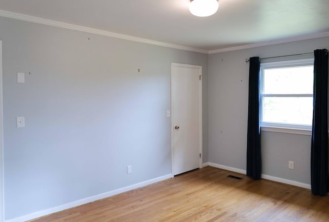 unfurnished room with crown molding, baseboards, visible vents, and light wood finished floors