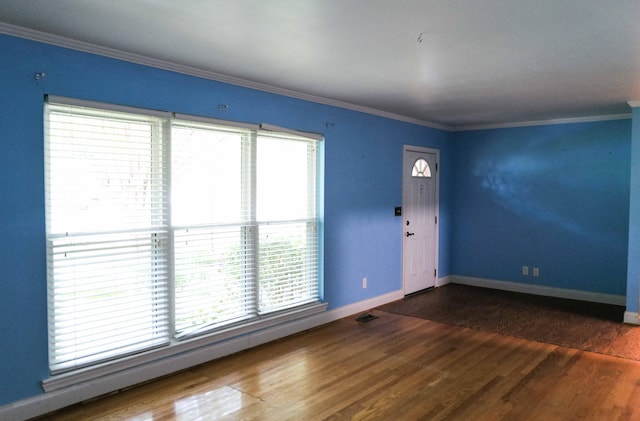 interior space with baseboards, ornamental molding, and wood finished floors