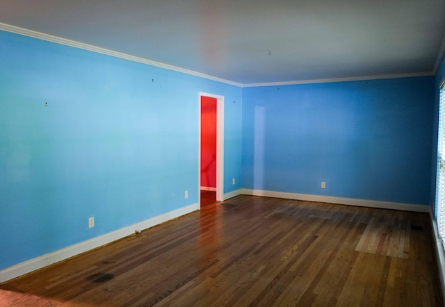 unfurnished room featuring baseboards, ornamental molding, and dark wood finished floors