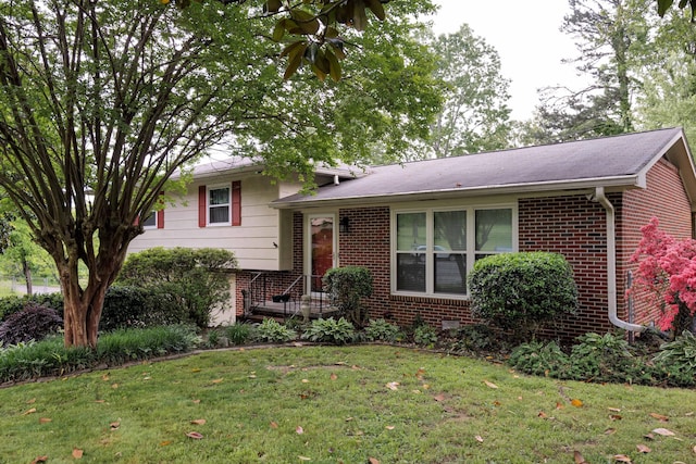 split level home with brick siding and a front yard