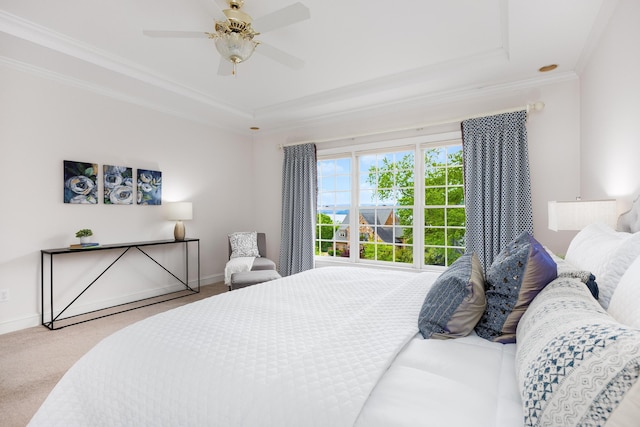 bedroom with baseboards, a tray ceiling, crown molding, and carpet floors