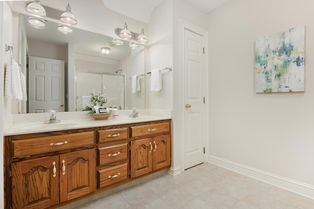 bathroom featuring a stall shower, tile patterned flooring, double vanity, and a sink