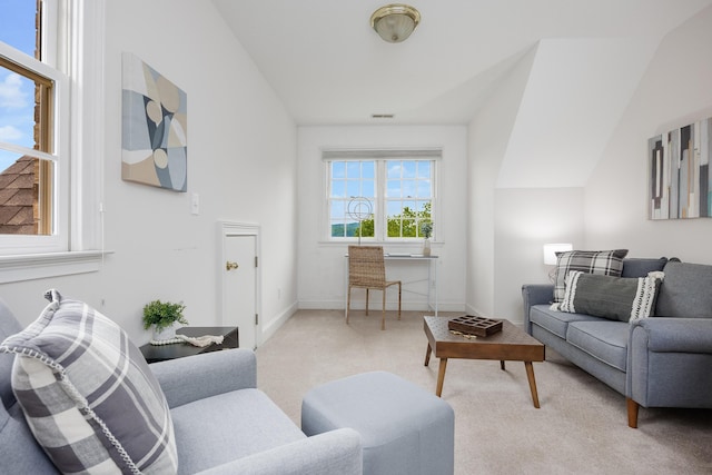 living area with baseboards, visible vents, light colored carpet, and vaulted ceiling