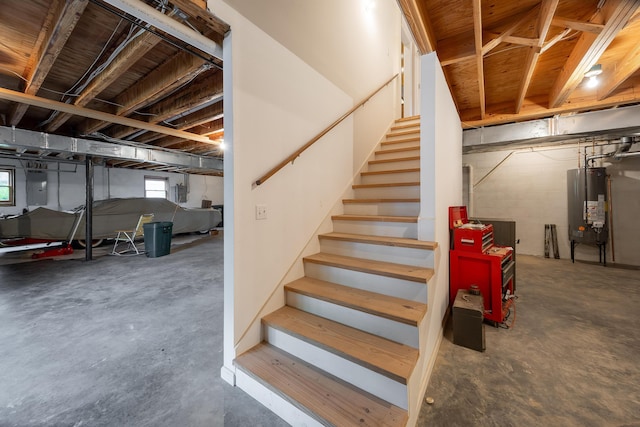 below grade area with stairs, electric panel, and gas water heater