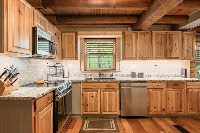 kitchen with light wood-style floors, a sink, appliances with stainless steel finishes, and wooden ceiling