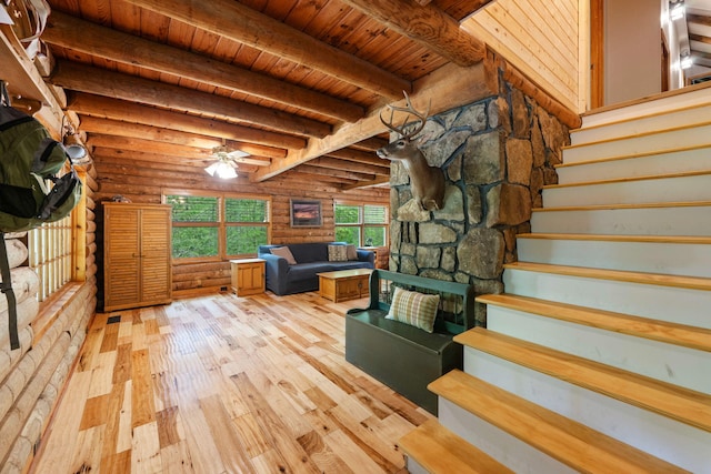 staircase featuring beamed ceiling, wood ceiling, rustic walls, and wood-type flooring