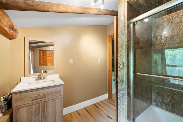 bathroom featuring an enclosed shower, beam ceiling, wood finished floors, and vanity