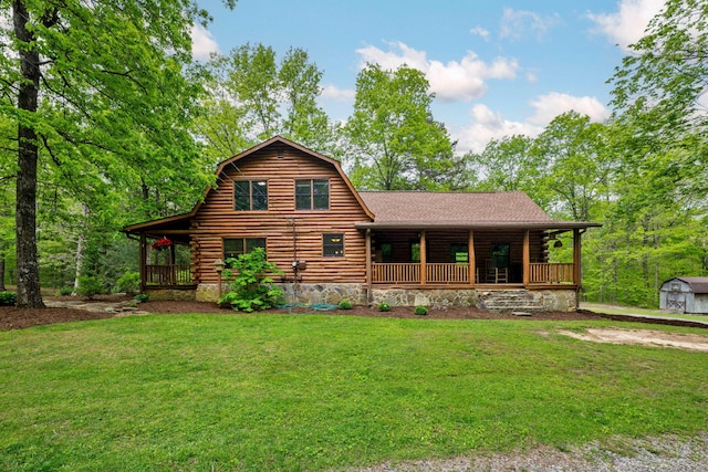 cabin with covered porch, log siding, and a front lawn