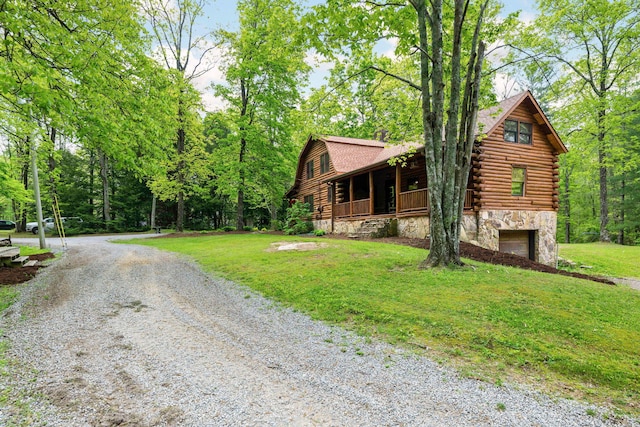 view of front of property with log siding, stone siding, a garage, a front yard, and gravel driveway