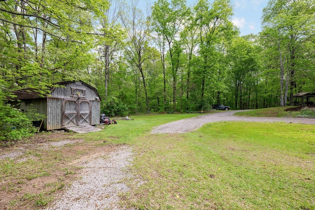 view of yard with an outbuilding, a shed, and a wooded view