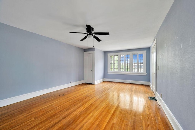 empty room with light wood-style flooring, ceiling fan, and baseboards