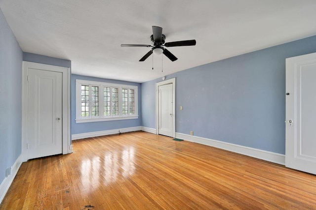 unfurnished bedroom featuring baseboards, light wood-style floors, and a ceiling fan