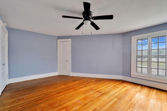 spare room with wood finished floors, baseboards, and a ceiling fan