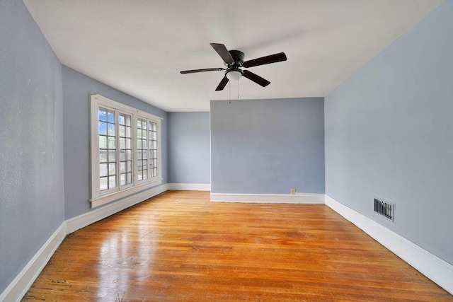 unfurnished room featuring hardwood / wood-style flooring, baseboards, and a ceiling fan