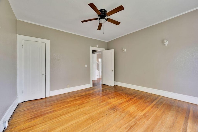 empty room with light wood-style flooring, ceiling fan, baseboards, and ornamental molding