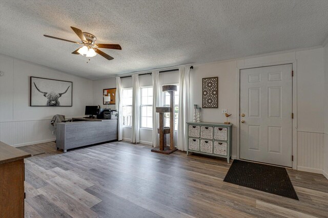 foyer featuring a textured ceiling, ceiling fan, and wood finished floors