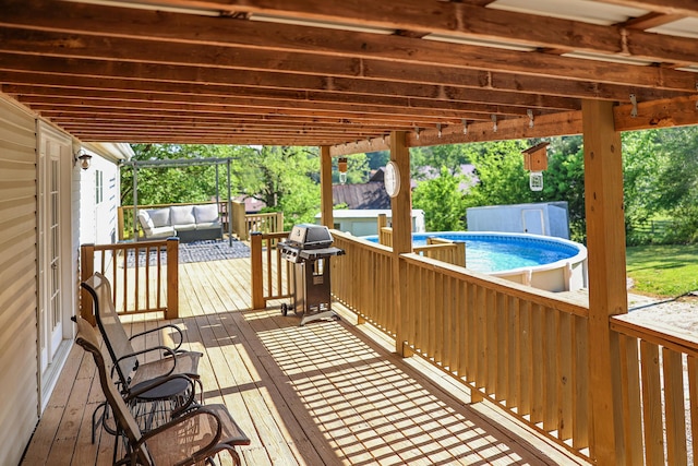 wooden terrace with an outdoor living space, area for grilling, and an outdoor pool
