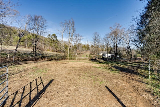 view of yard with fence and a rural view