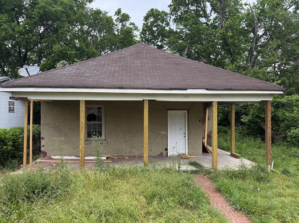 view of front of house with roof with shingles and stucco siding