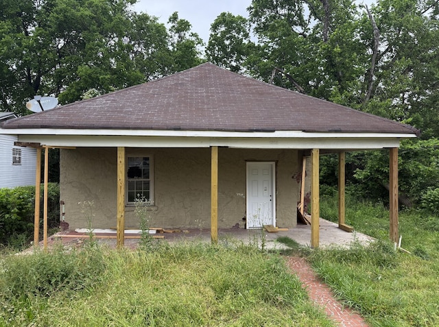 view of front of house with roof with shingles and stucco siding