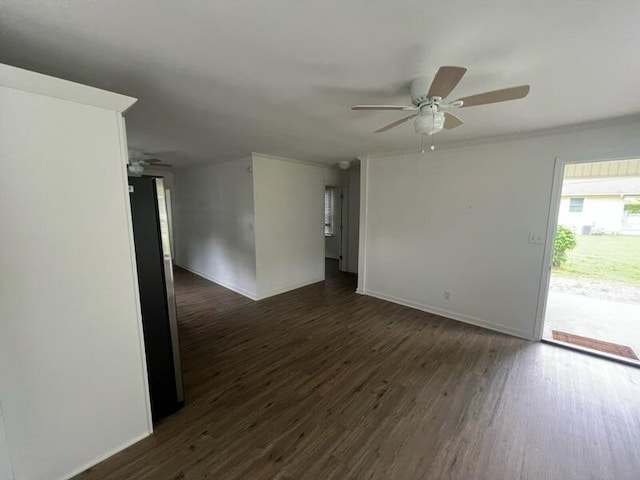 spare room with dark wood-type flooring, baseboards, and ceiling fan