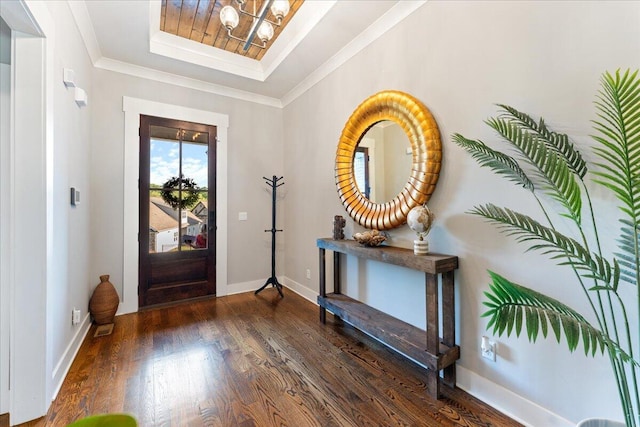 entryway with baseboards, a notable chandelier, wood finished floors, and a raised ceiling