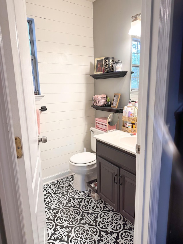 8721 Forest Pond Dr, Harrison, TN 37341 - half bath featuring wooden walls, vanity, tile patterned flooring, and toilet