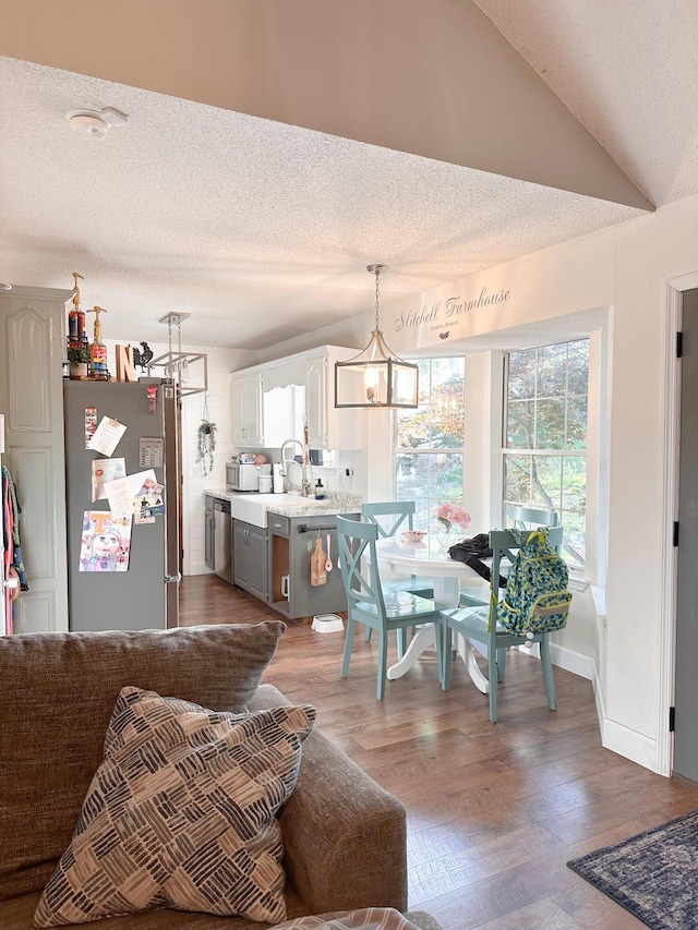 8721 Forest Pond Dr, Harrison, TN 37341 - living room with a textured ceiling, an inviting chandelier, wood finished floors, and lofted ceiling