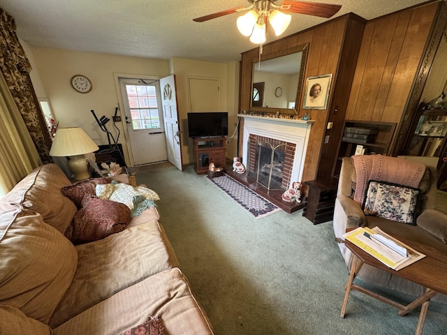 carpeted living room with a ceiling fan, a textured ceiling, and a fireplace