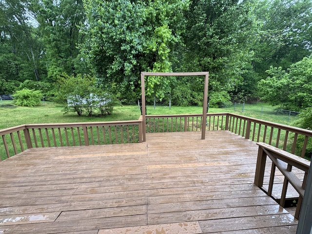 deck with a lawn and fence