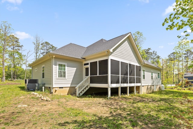 rear view of house with roof with shingles, a yard, and a sunroom