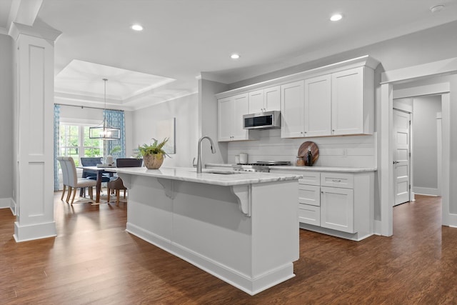 kitchen featuring dark wood-style flooring, a sink, recessed lighting, stainless steel microwave, and baseboards