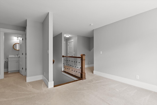 empty room with baseboards and light carpet